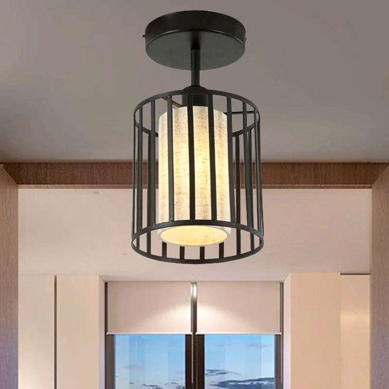 Een lichte cilinder/barrel semi-inbouw licht industrieel zwart metalen verlichtingsarmatuur voor gang met stoffen kap Clea...