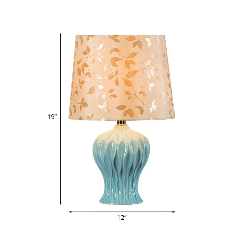 Met bladeren bedrukte stof Beige nachtlampje met tonvormige kap Traditionele tafelverlichting met 1 licht en blauwe urnbas...