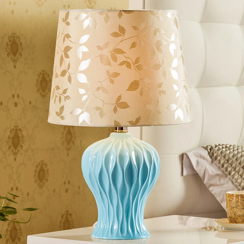 Met bladeren bedrukte stof Beige nachtlampje met tonvormige kap Traditionele tafelverlichting met 1 licht en blauwe urnbas...